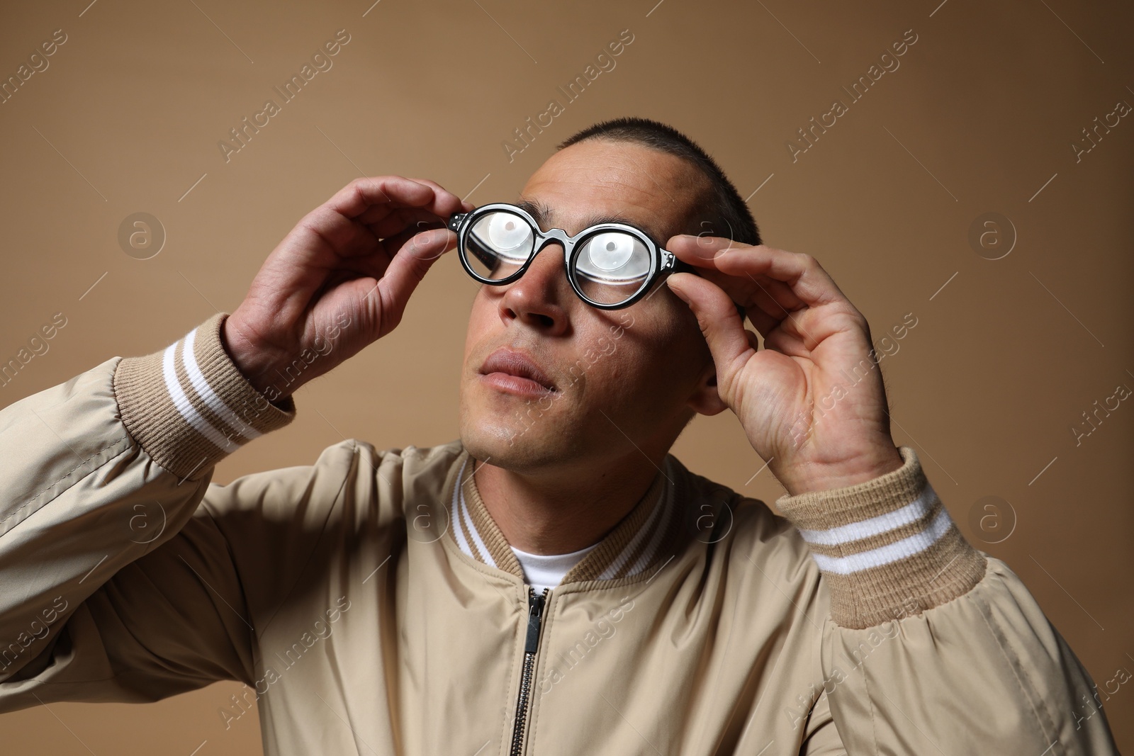 Fashionable portrait of handsome man in stylish outfit on brown background Photo of Fashionable portrait of handsome man in stylish outfit on brown background