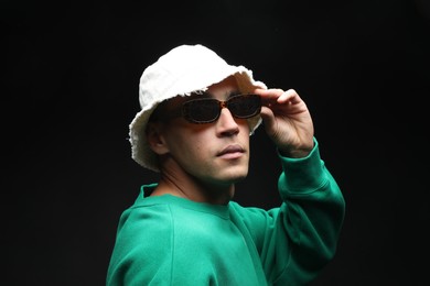 Photo of Fashionable portrait of handsome man in stylish outfit on black background