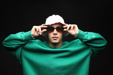 Photo of Fashionable portrait of handsome man in stylish outfit on black background