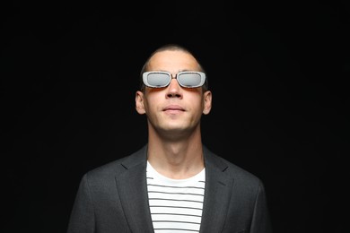 Photo of Fashionable portrait of handsome man in stylish outfit on black background