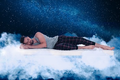 Image of Young man sleeping on comfortable mattress as soft as cloud in starry sky at night