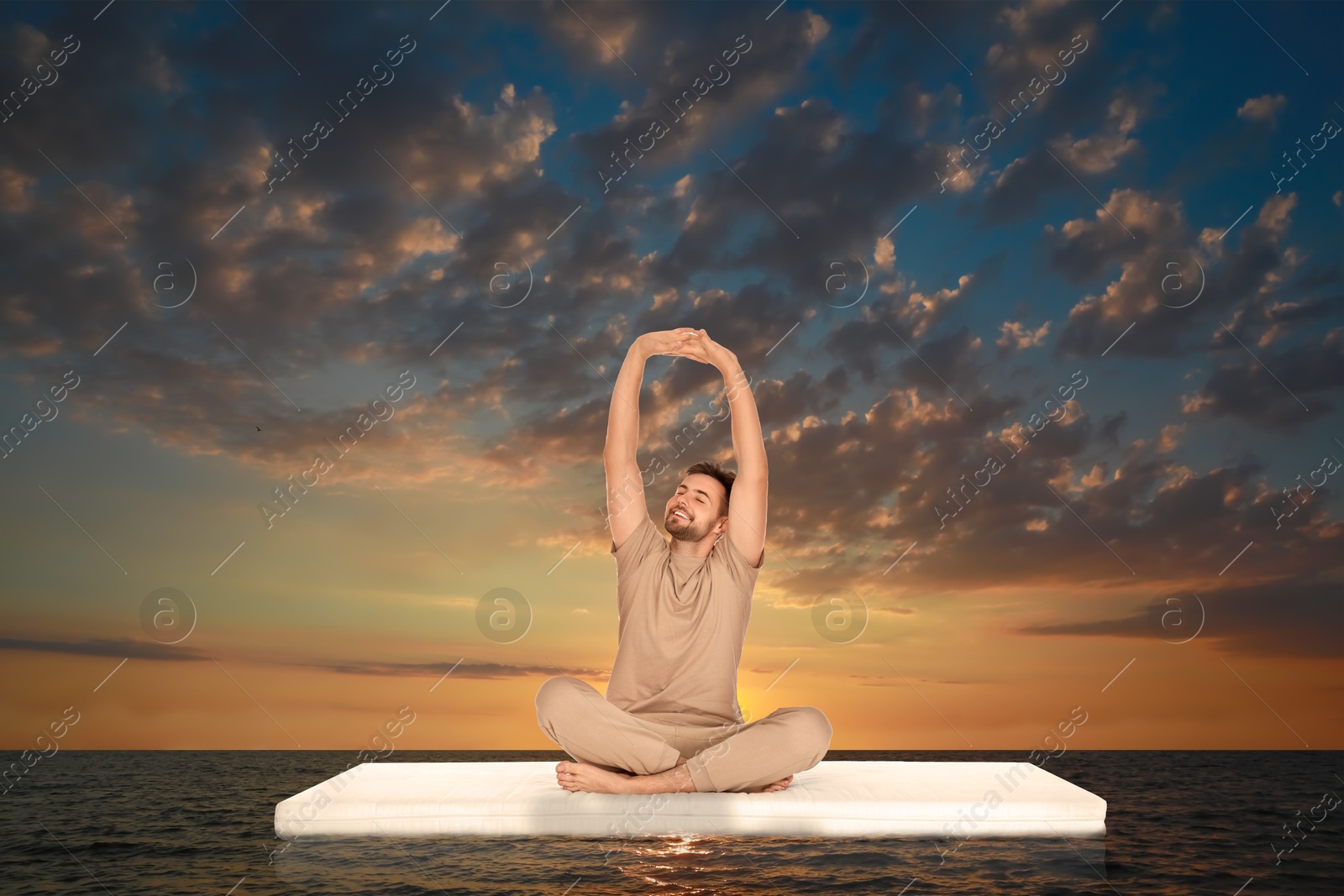 Young man on comfortable mattress in sea at sunset Image of Young man on comfortable mattress in sea at sunset