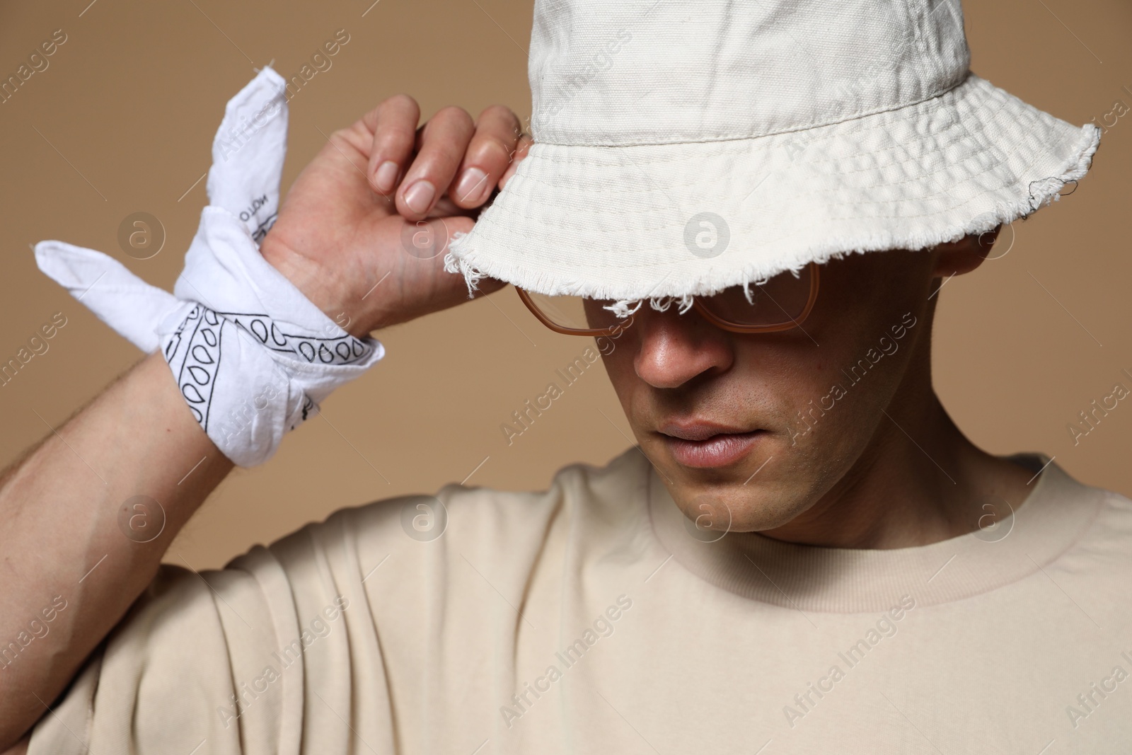 Fashionable portrait of handsome man in stylish outfit on brown background Photo of Fashionable portrait of handsome man in stylish outfit on brown background