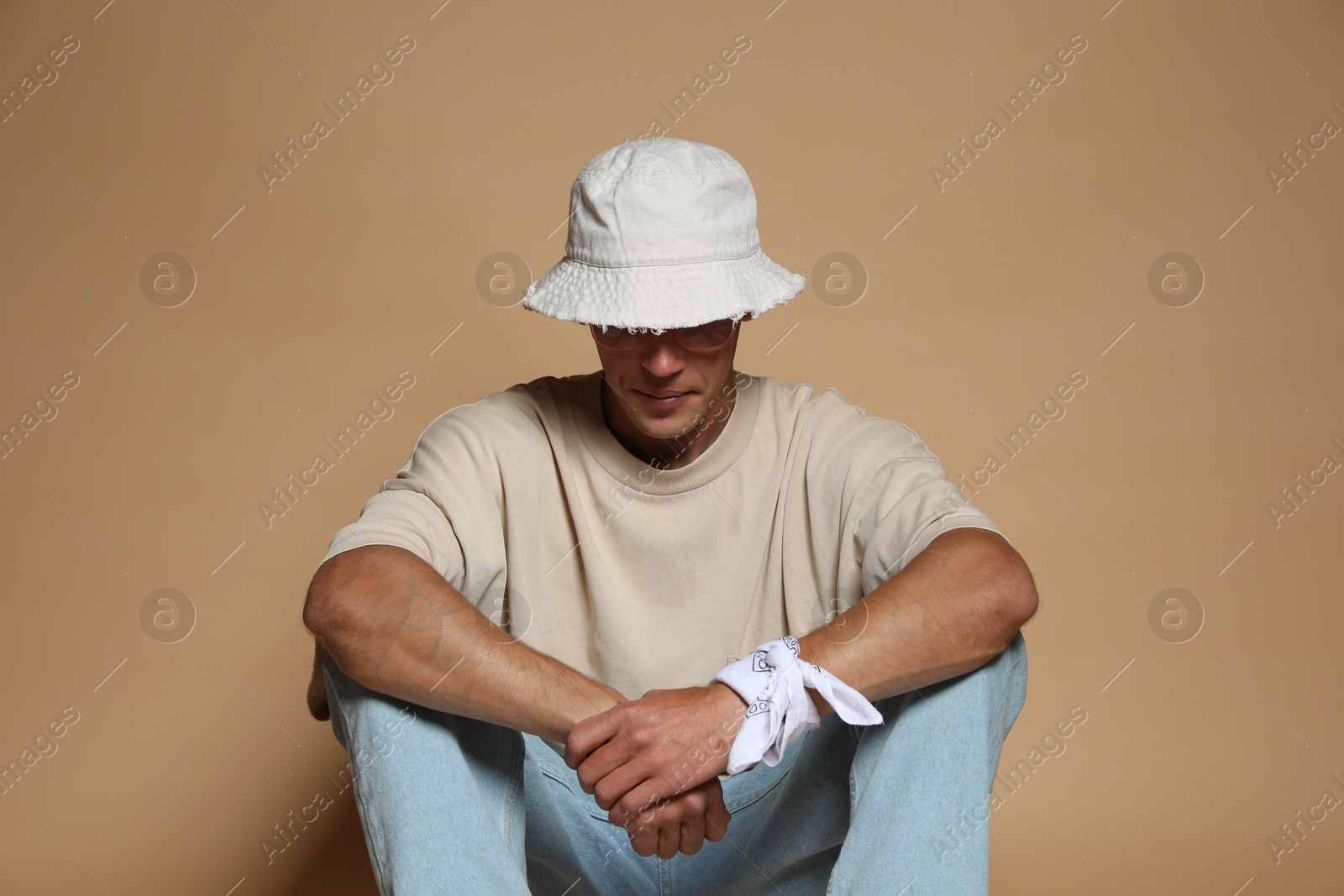 Fashionable portrait of handsome man in stylish outfit on brown background Photo of Fashionable portrait of handsome man in stylish outfit on brown background