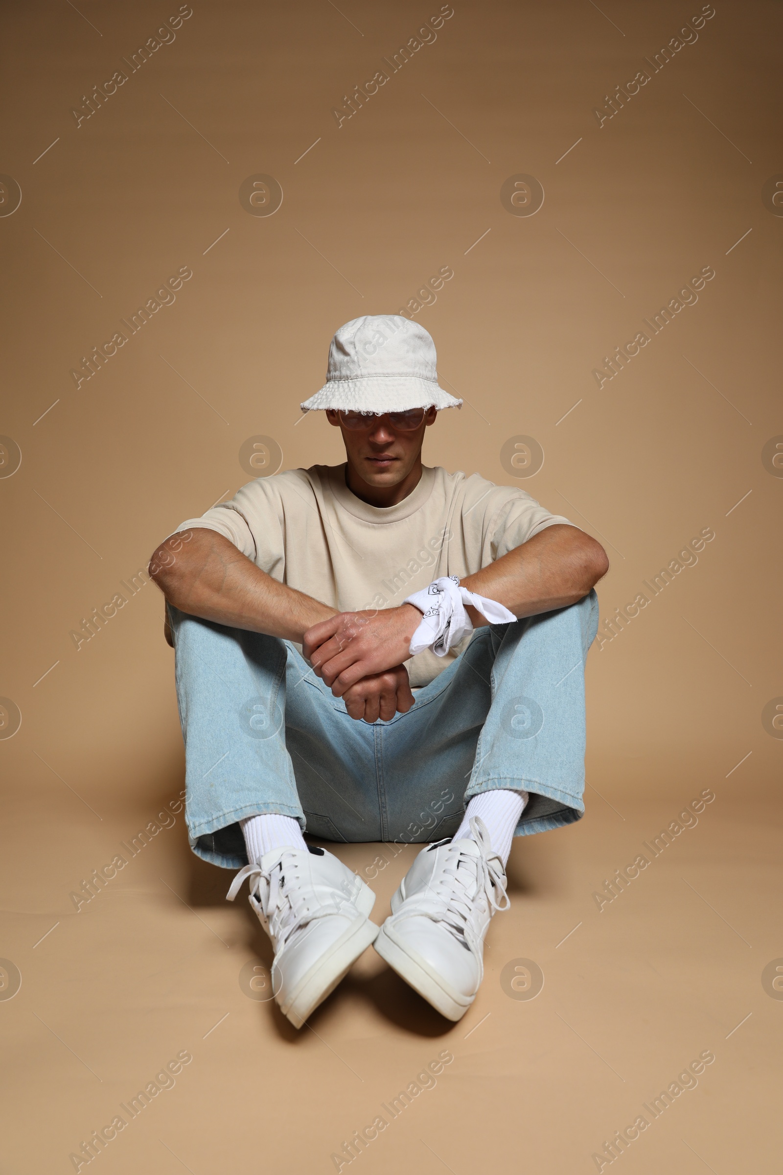 Fashionable portrait of handsome man in stylish outfit on brown background Photo of Fashionable portrait of handsome man in stylish outfit on brown background