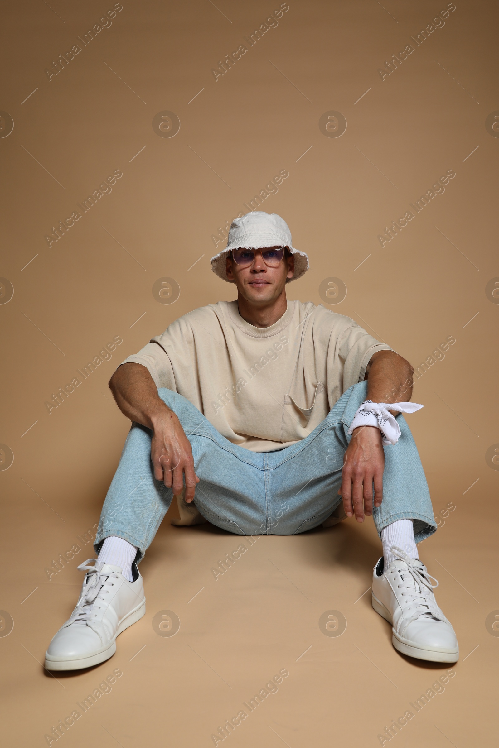 Fashionable portrait of handsome man in stylish outfit on brown background Photo of Fashionable portrait of handsome man in stylish outfit on brown background