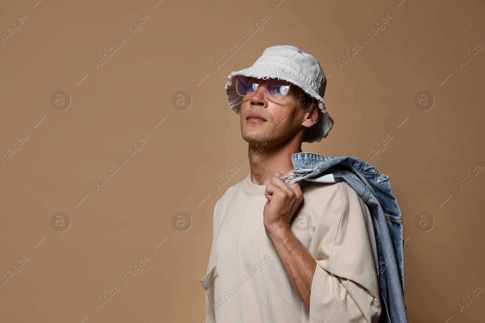 Fashionable portrait of handsome man in stylish outfit on brown background, space for text Photo of Fashionable portrait of handsome man in stylish outfit on brown background, space for text
