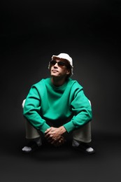 Photo of Fashionable portrait of handsome man in stylish outfit on black background