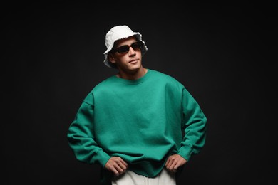 Photo of Fashionable portrait of handsome man in stylish outfit on black background