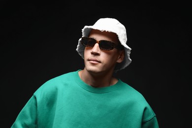 Photo of Fashionable portrait of handsome man in stylish outfit on black background