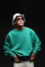 Photo of Fashionable portrait of handsome man in stylish outfit on black background