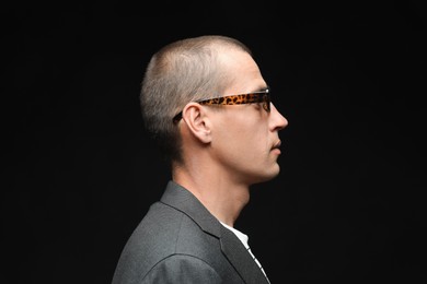 Photo of Fashionable portrait of handsome man in stylish outfit on black background