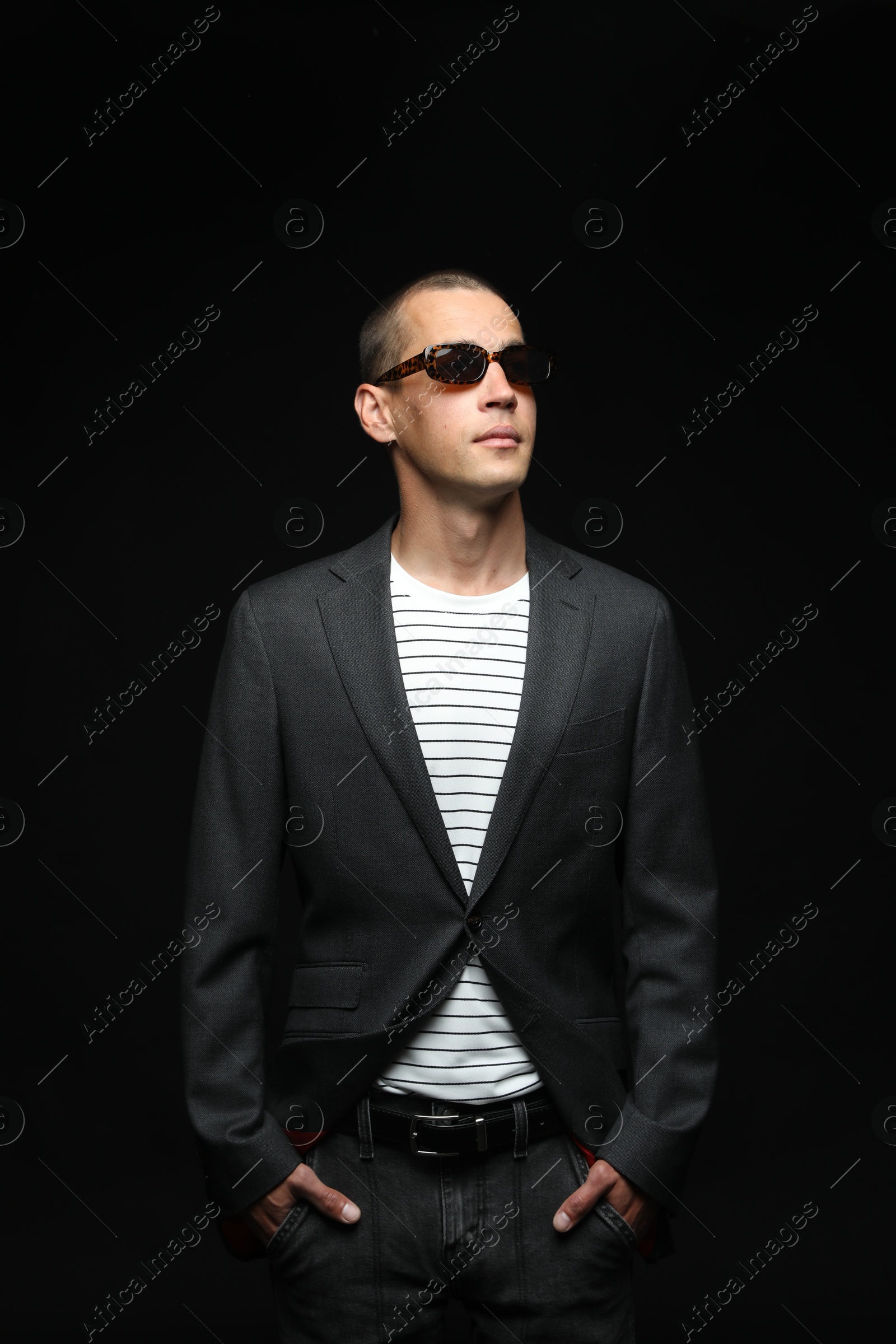 Fashionable portrait of handsome man in stylish outfit on black background Photo of Fashionable portrait of handsome man in stylish outfit on black background