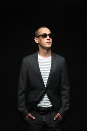 Photo of Fashionable portrait of handsome man in stylish outfit on black background