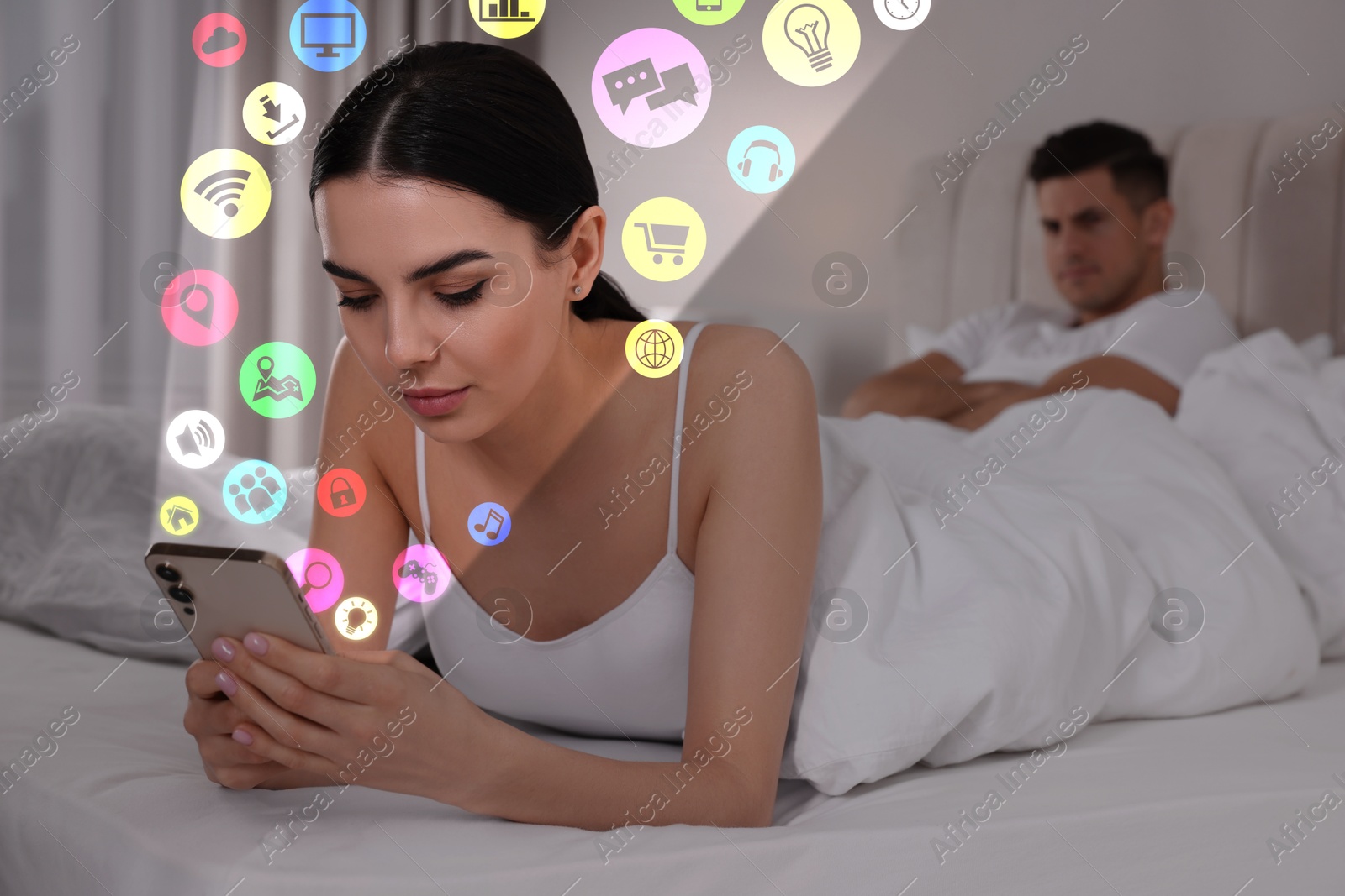 Internet addicted woman using mobile phone instead of spending time with her boyfriend at home. Different icons flying out of device Image of Internet addicted woman using mobile phone instead of spending time with her boyfriend at home. Different icons flying out of device
