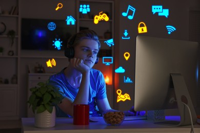 Image of Internet addicted teenager using computer instead of sleeping at night. Different icons near him