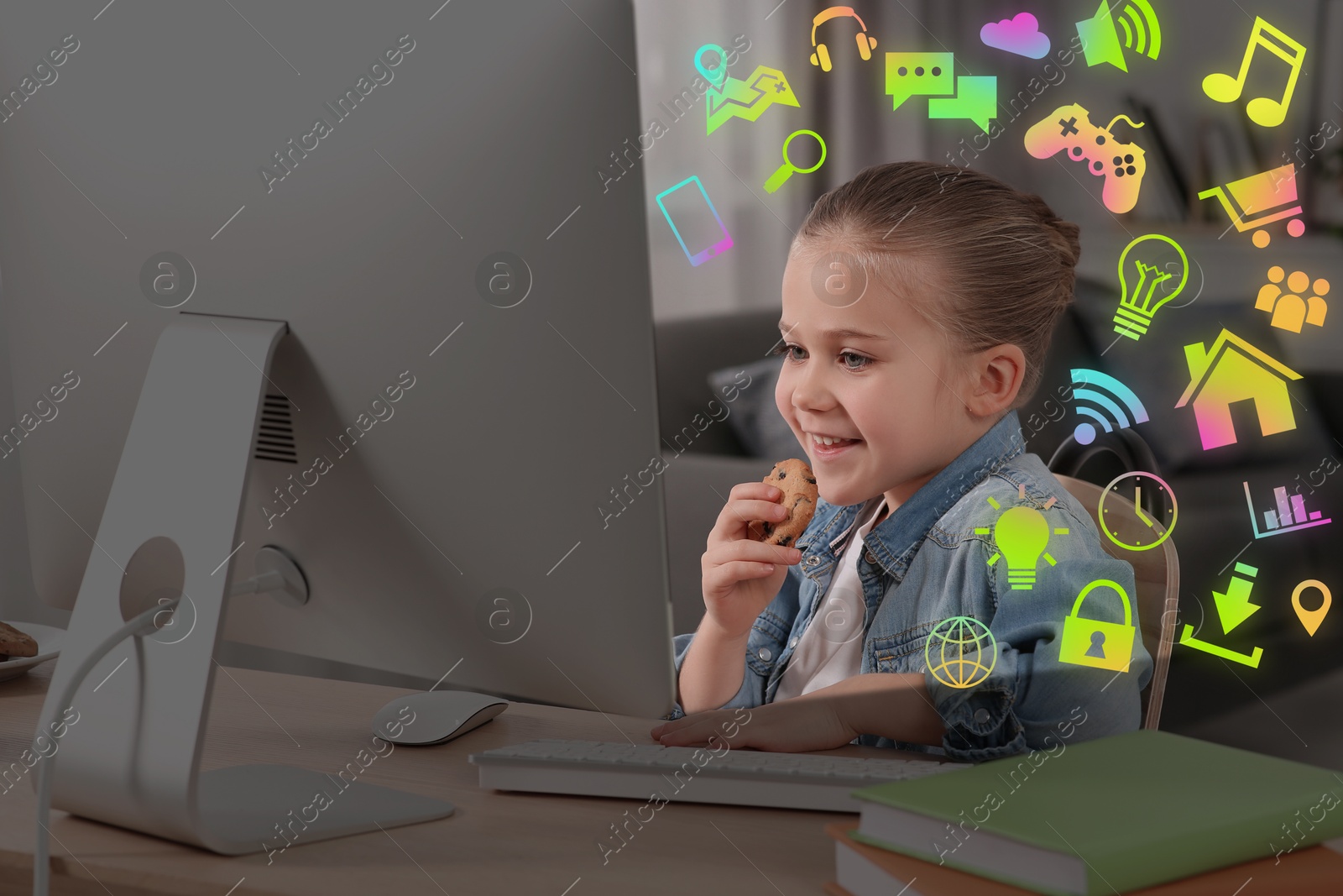 Internet addicted child using computer and eating cookie at table. Different icons around her Image of Internet addicted child using computer and eating cookie at table. Different icons around her