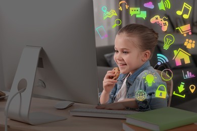 Image of Internet addicted child using computer and eating cookie at table. Different icons around her