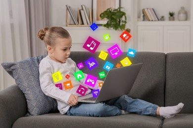 Image of Internet addicted child using laptop at home. Different icons flying out of computer