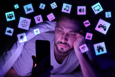 Image of Internet addicted man using mobile phone instead of sleeping at night. Different icons near him