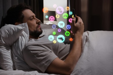 Image of Internet addicted man using mobile phone instead of sleeping at night. Different icons flying out of device