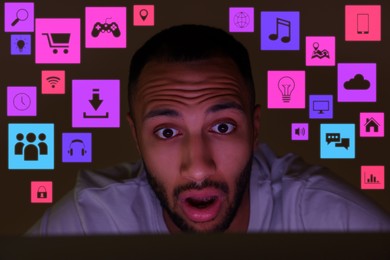 Image of Internet addicted man using laptop instead of sleeping at night. Different icons near him