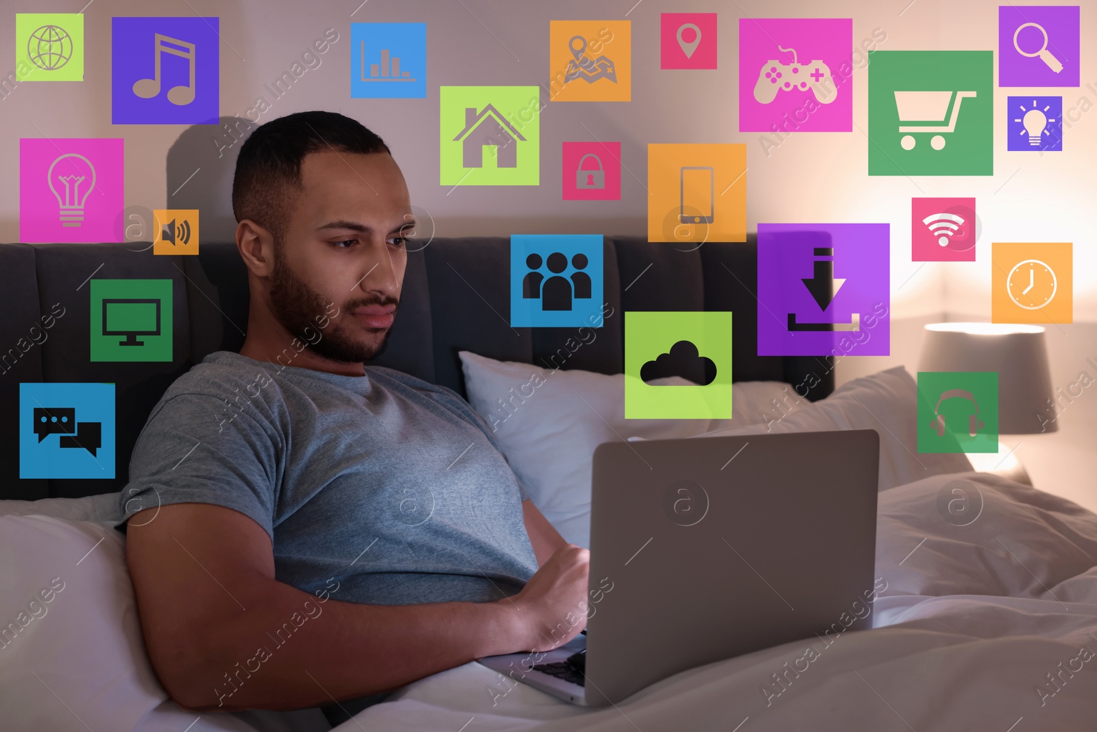 Internet addicted man using laptop instead of sleeping at night. Different icons near him Image of Internet addicted man using laptop instead of sleeping at night. Different icons near him