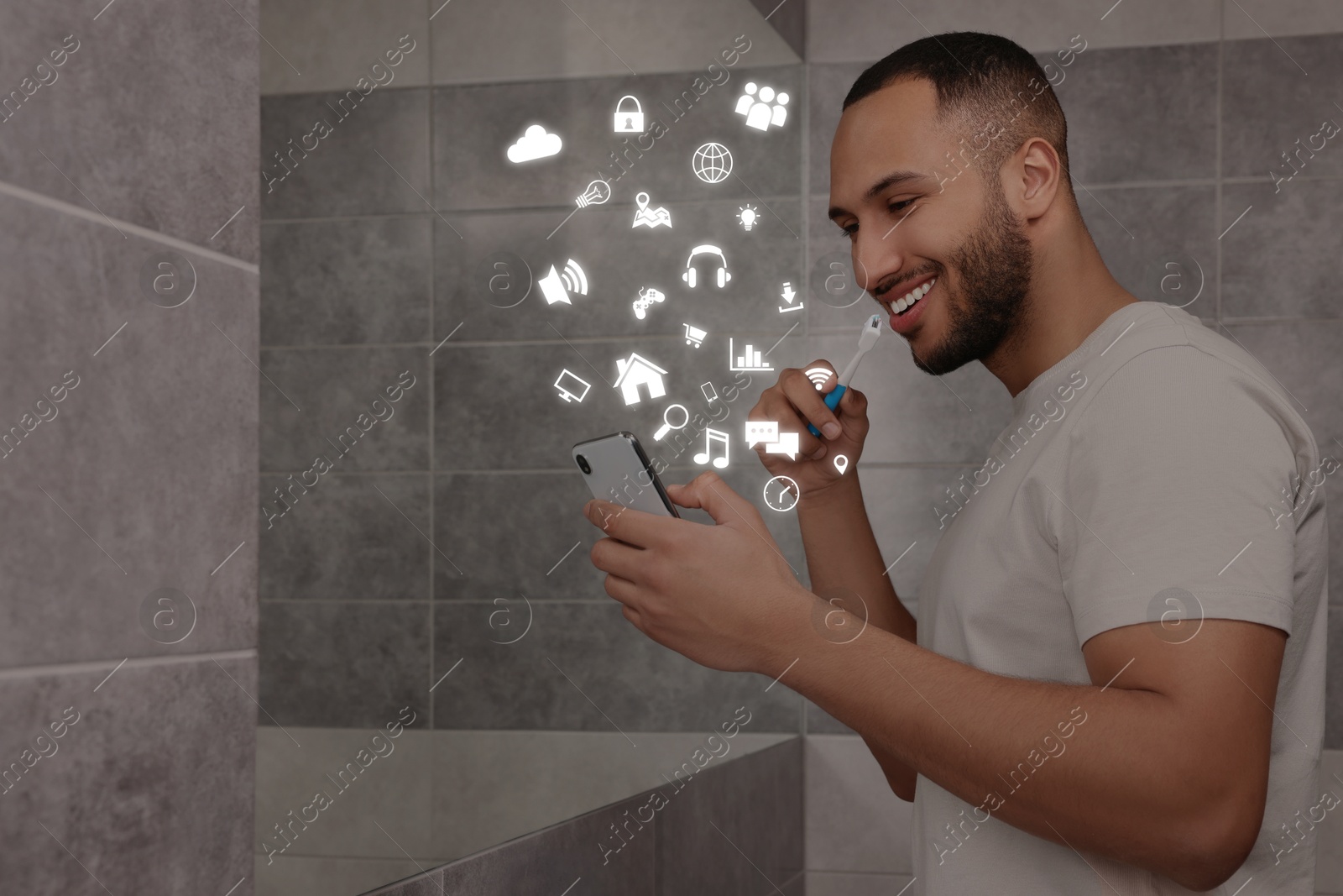 Internet addicted man using mobile phone while brushing teeth in bathroom. Different icons flying out of device Image of Internet addicted man using mobile phone while brushing teeth in bathroom. Different icons flying out of device