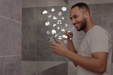 Image of Internet addicted man using mobile phone while brushing teeth in bathroom. Different icons flying out of device