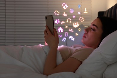 Image of Internet addicted woman using mobile phone instead of sleeping at night. Different icons flying out of device