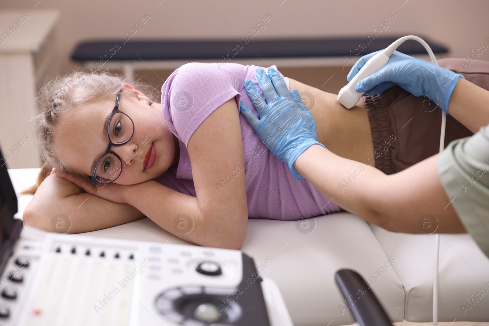 Sonographer conducting girl's renal ultrasound examination in clinic, closeup Photo of Sonographer conducting girl's renal ultrasound examination in clinic, closeup