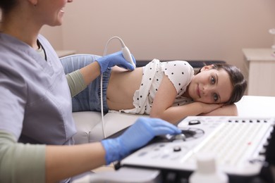 Photo of Sonographer conducting girl's renal ultrasound examination in clinic, closeup