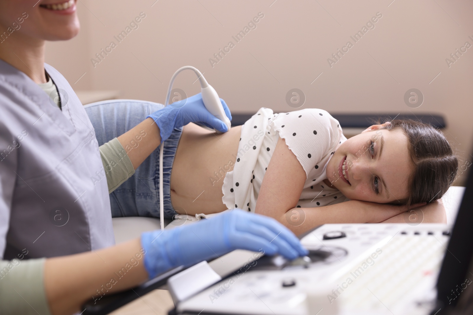 Sonographer conducting girl's renal ultrasound examination in clinic, closeup Photo of Sonographer conducting girl's renal ultrasound examination in clinic, closeup