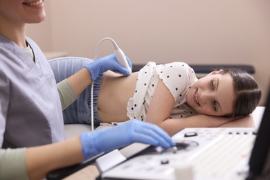 Photo of Sonographer conducting girl's renal ultrasound examination in clinic, closeup