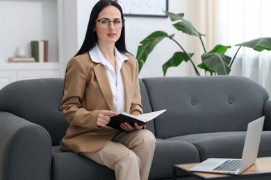 Photo of Professional psychologist with notebook and laptop in office