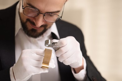 Photo of Appraiser with loupe evaluating luxury bracelet indoors, space for text
