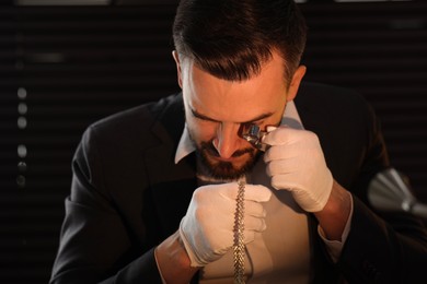 Photo of Appraiser with loupe evaluating luxury jewelry indoors