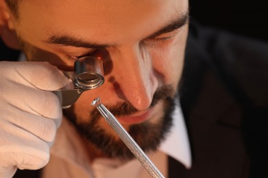 Photo of Appraiser with loupe evaluating luxury gemstone indoors, closeup