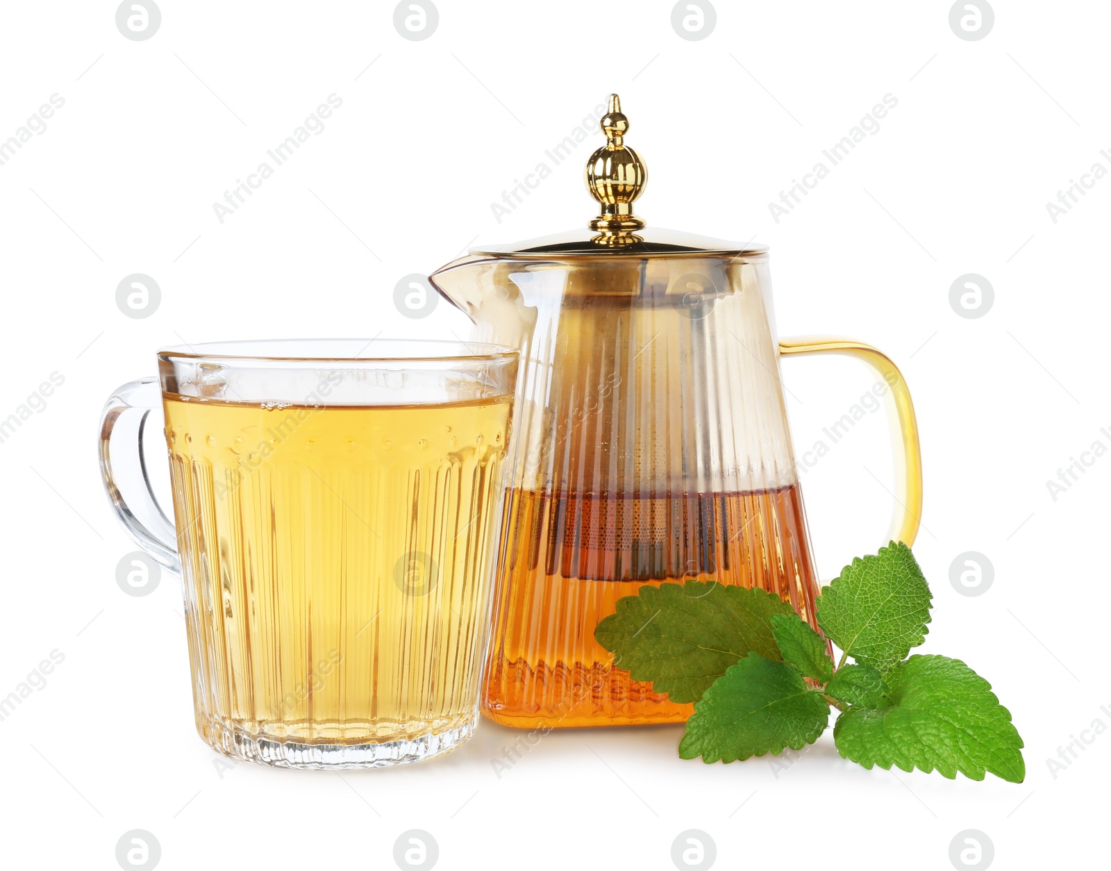 Aromatic lemon balm tea in glass cup, teapot and fresh leaves isolated on white Photo of Aromatic lemon balm tea in glass cup, teapot and fresh leaves isolated on white