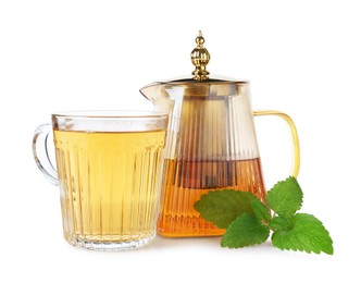 Photo of Aromatic lemon balm tea in glass cup, teapot and fresh leaves isolated on white