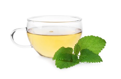 Photo of Aromatic lemon balm tea in glass cup and fresh leaves isolated on white