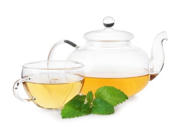 Photo of Aromatic lemon balm tea in glass cup, teapot and fresh leaves isolated on white