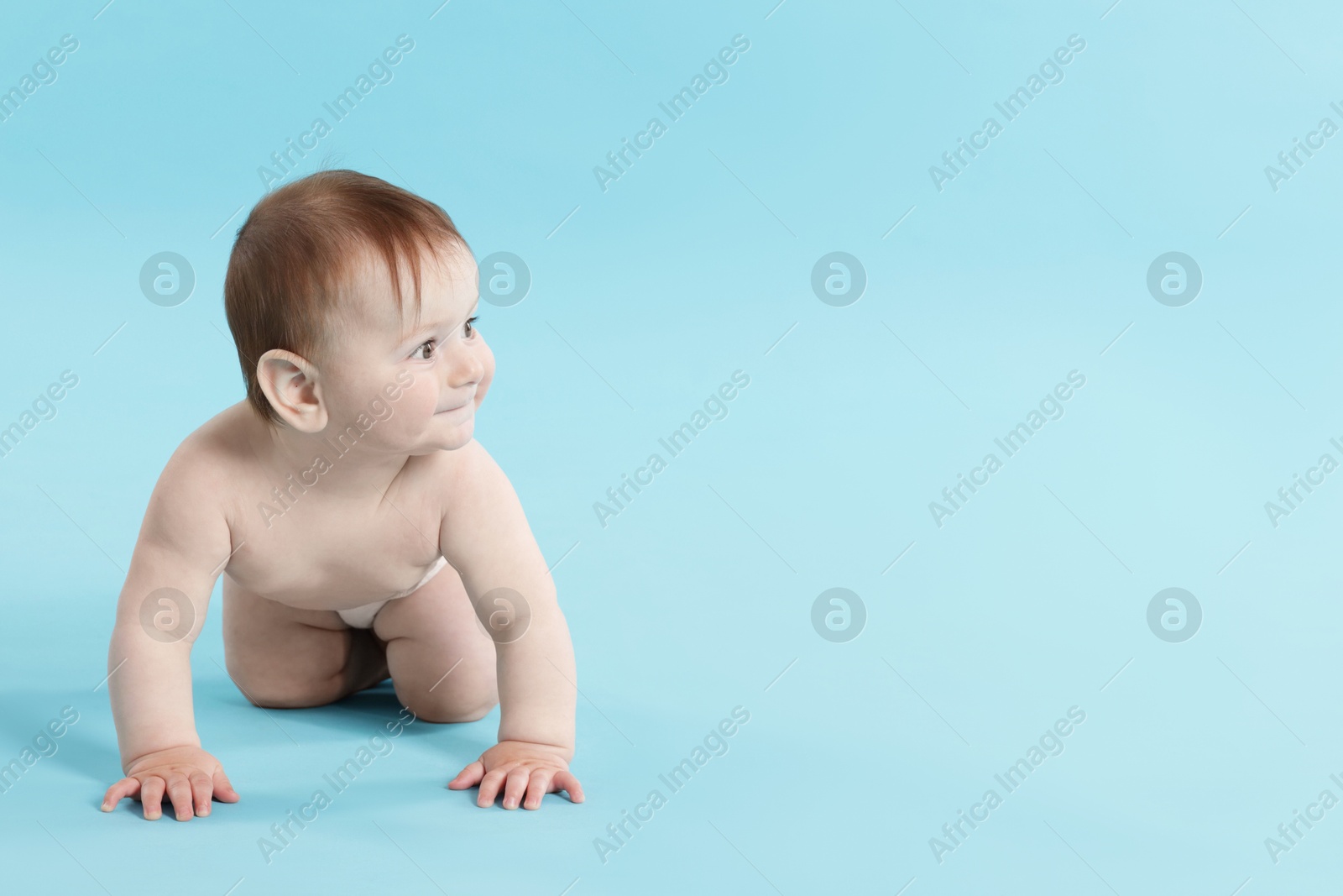 Cute little baby crawling on light blue background. Space for text Photo of Cute little baby crawling on light blue background. Space for text