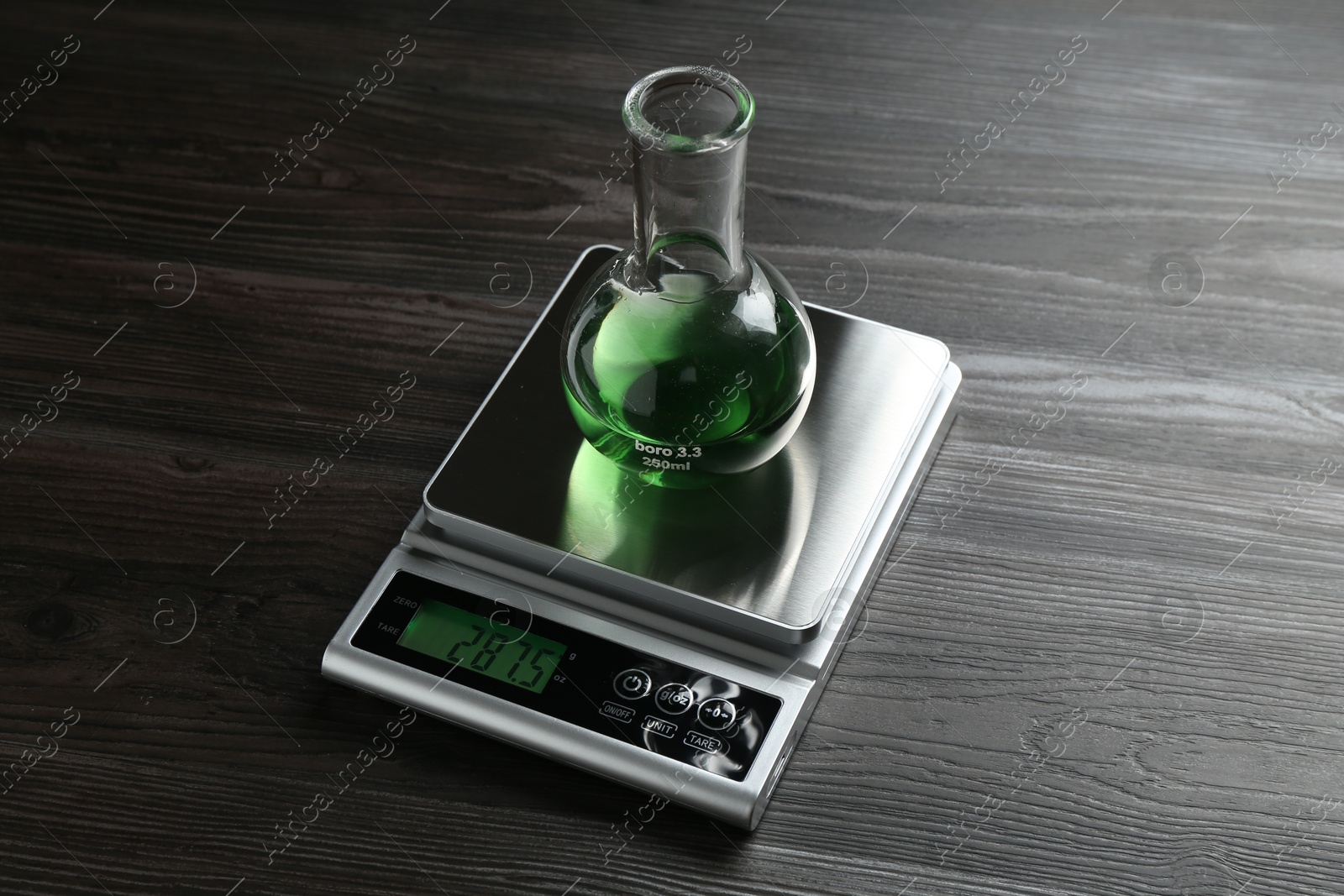 Laboratory scale with flask of sample on wooden table Photo of Laboratory scale with flask of sample on wooden table