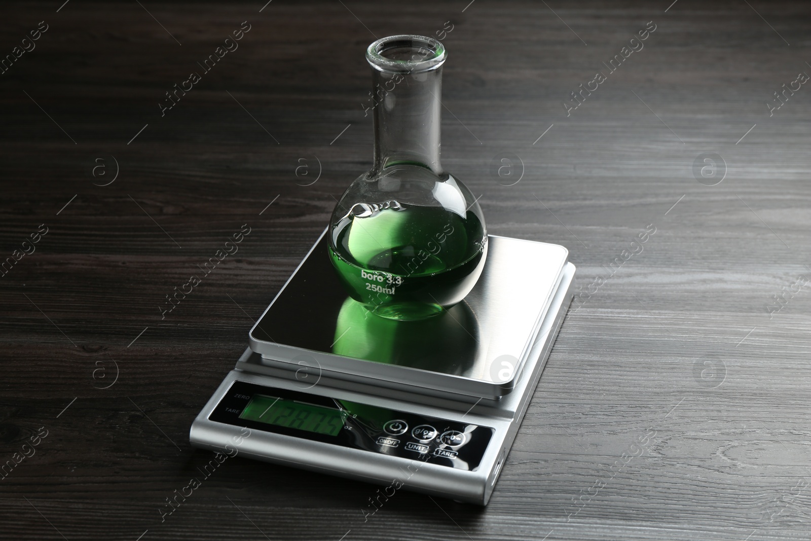 Laboratory scale with flask of sample on wooden table Photo of Laboratory scale with flask of sample on wooden table