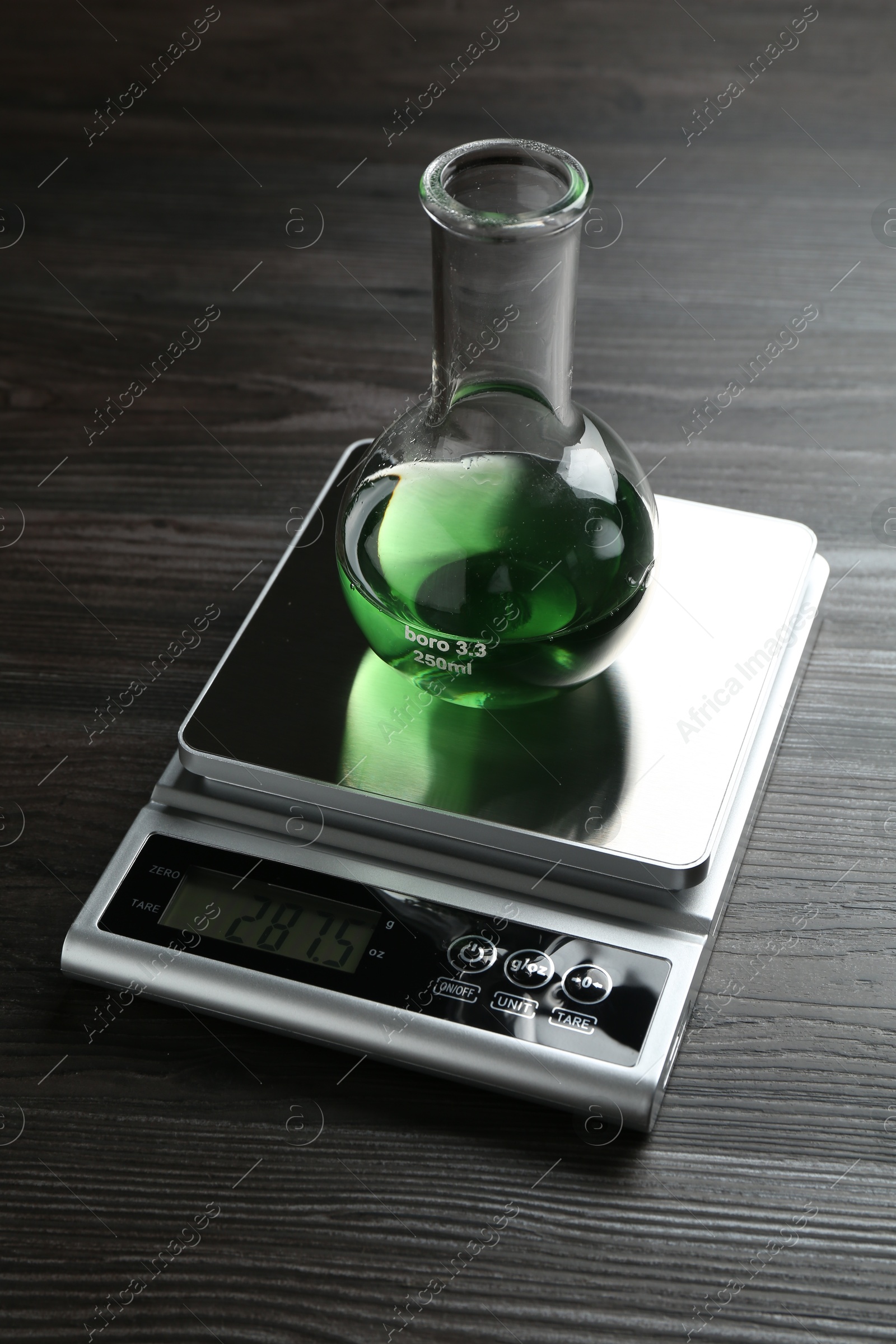 Laboratory scale with flask of sample on wooden table Photo of Laboratory scale with flask of sample on wooden table