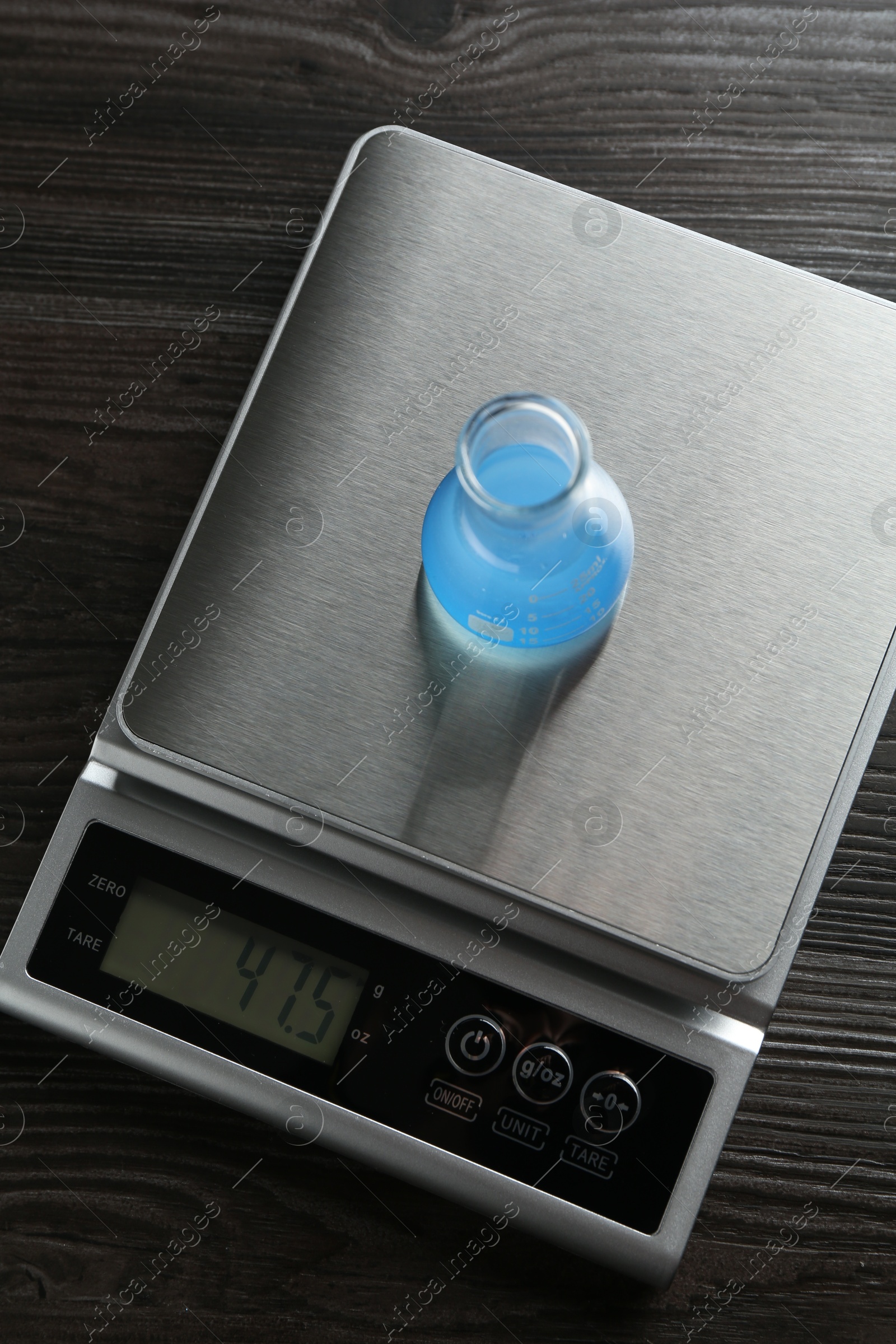 Laboratory scale with flask of sample on wooden table, top view Photo of Laboratory scale with flask of sample on wooden table, top view