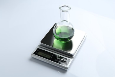 Photo of Laboratory scale with flask of sample on white background