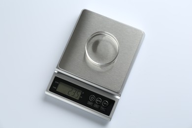 Photo of Laboratory scale with Petri dish on white background, top view