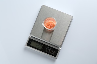 Photo of Laboratory scale with beaker of sample on white background, top view